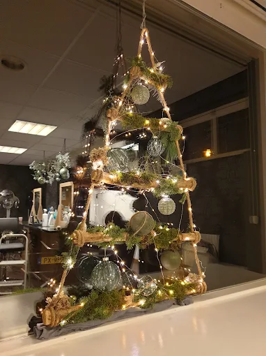 Handgemaakte houten kerstboom met verlichting en kerstballen, te zien in etalage in Medemblik – inspiratie voor een unieke kerstboom Medemblik.